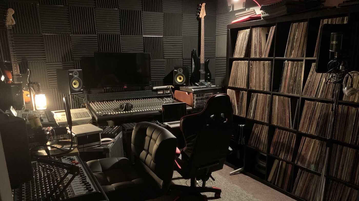 The GPSCIENCE studio: foam-panelled walls, a mixing desk, studio monitors, a bass and a wall of vinyl records